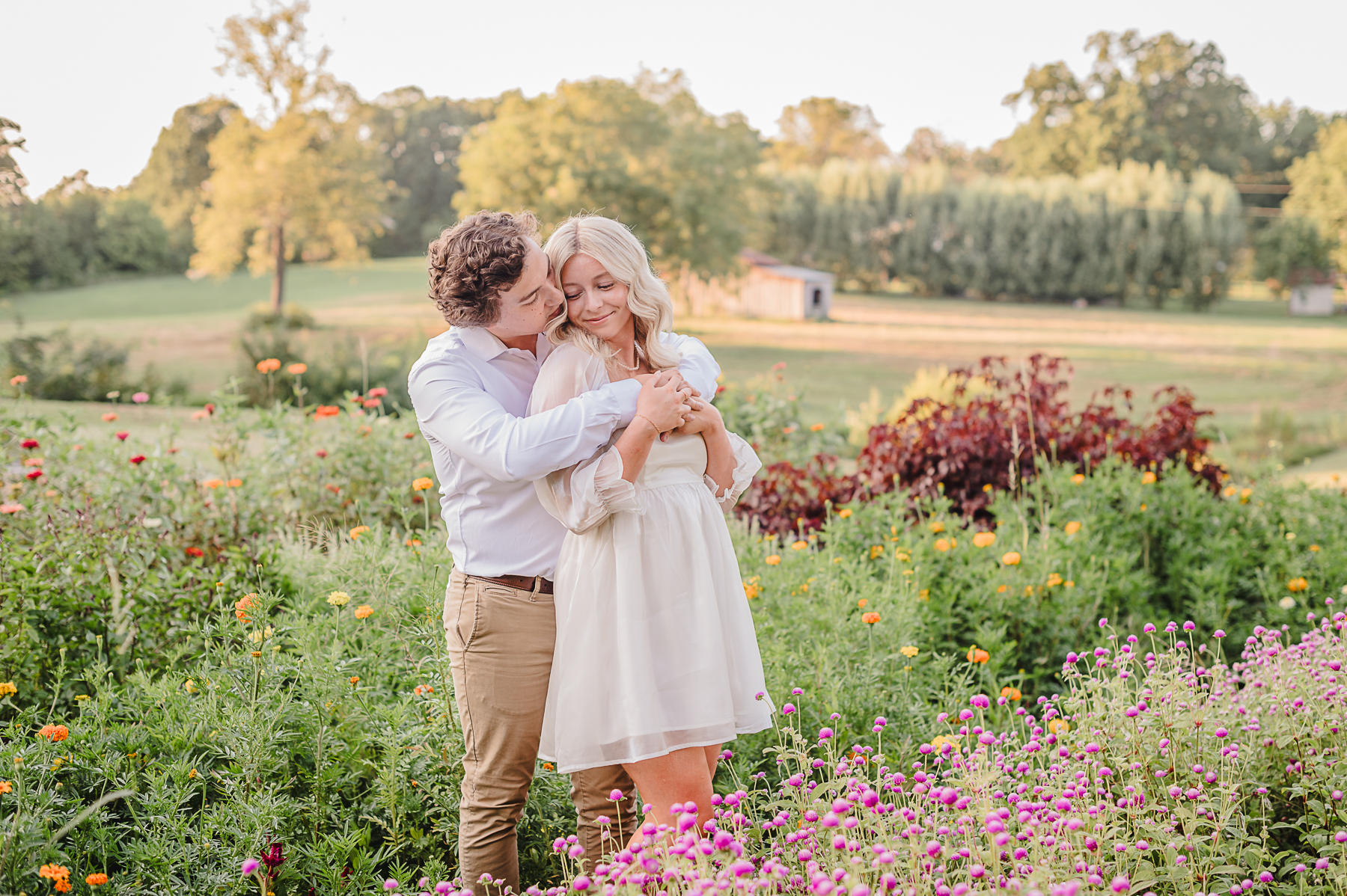 Young engaged couple standing in flower field for professional photography session