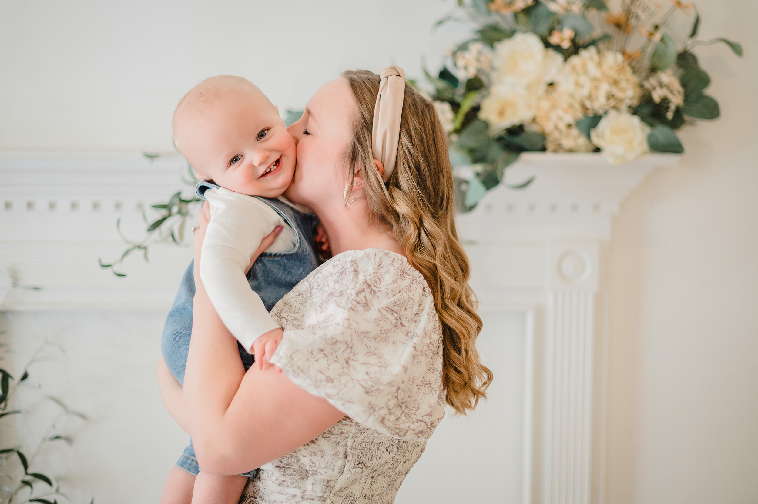 Mother kissing her baby during a motherhood session in Salisbury NC with soft natural light